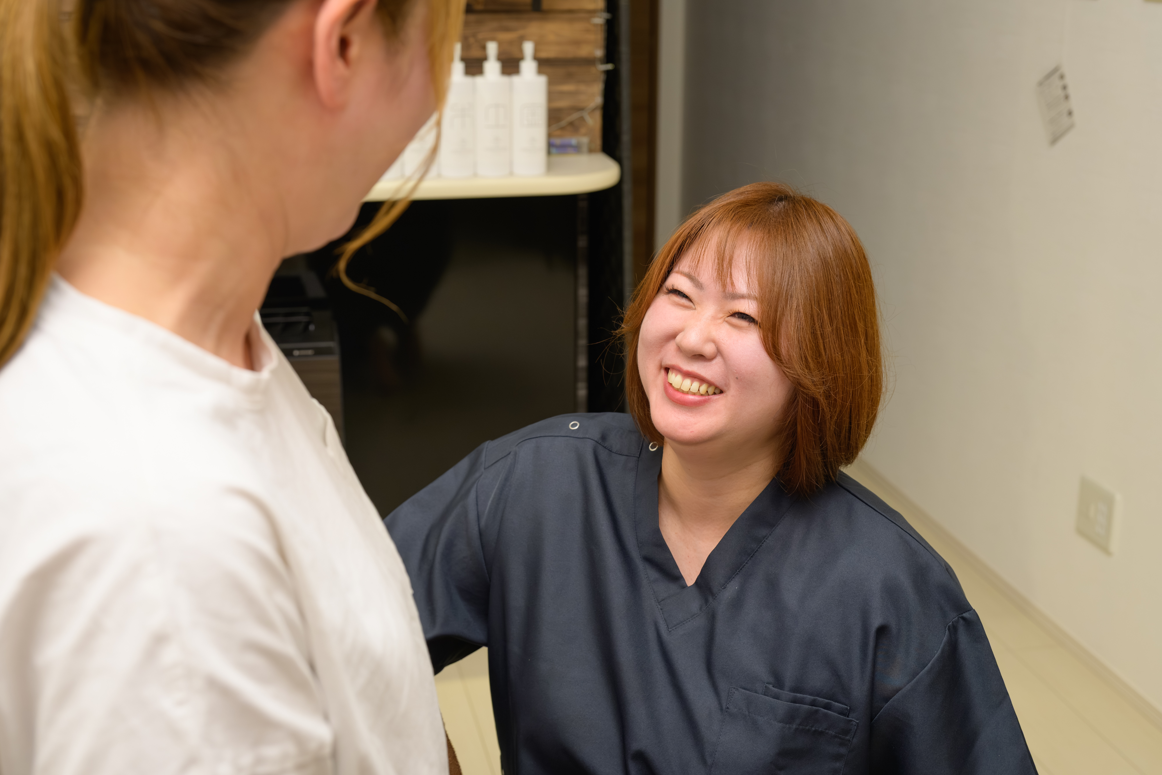 お客様と笑顔で会話する整体師